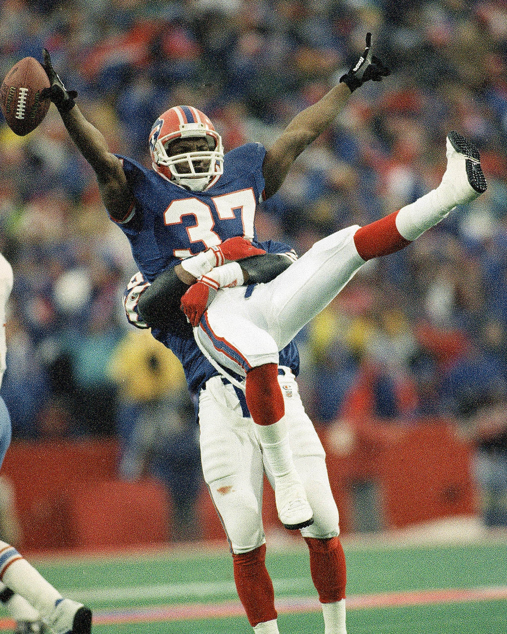 Buffalo Bills cornerback Nate Odomes gets a lift from teammate Henry Jones after intercepting a pass by the Houston Oilers during the overtime period to set up Steve Christie's game winning field goal. (AP Photo/Bill Sikes)